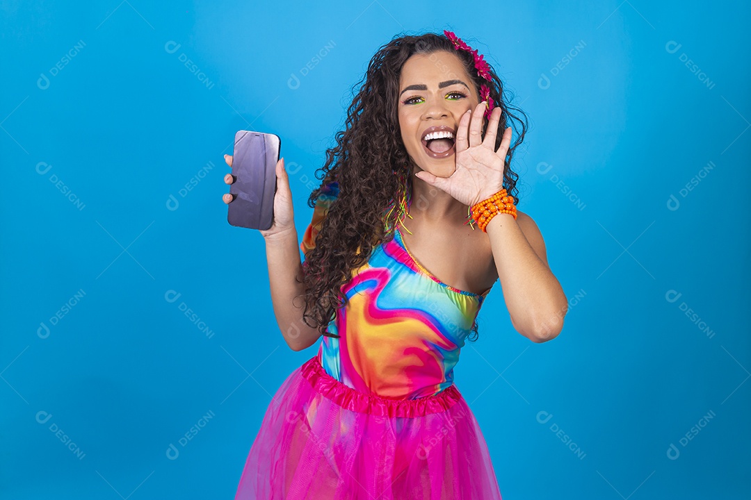 Mulher de cabelo cacheado com fantasia de carnaval segurando celular.