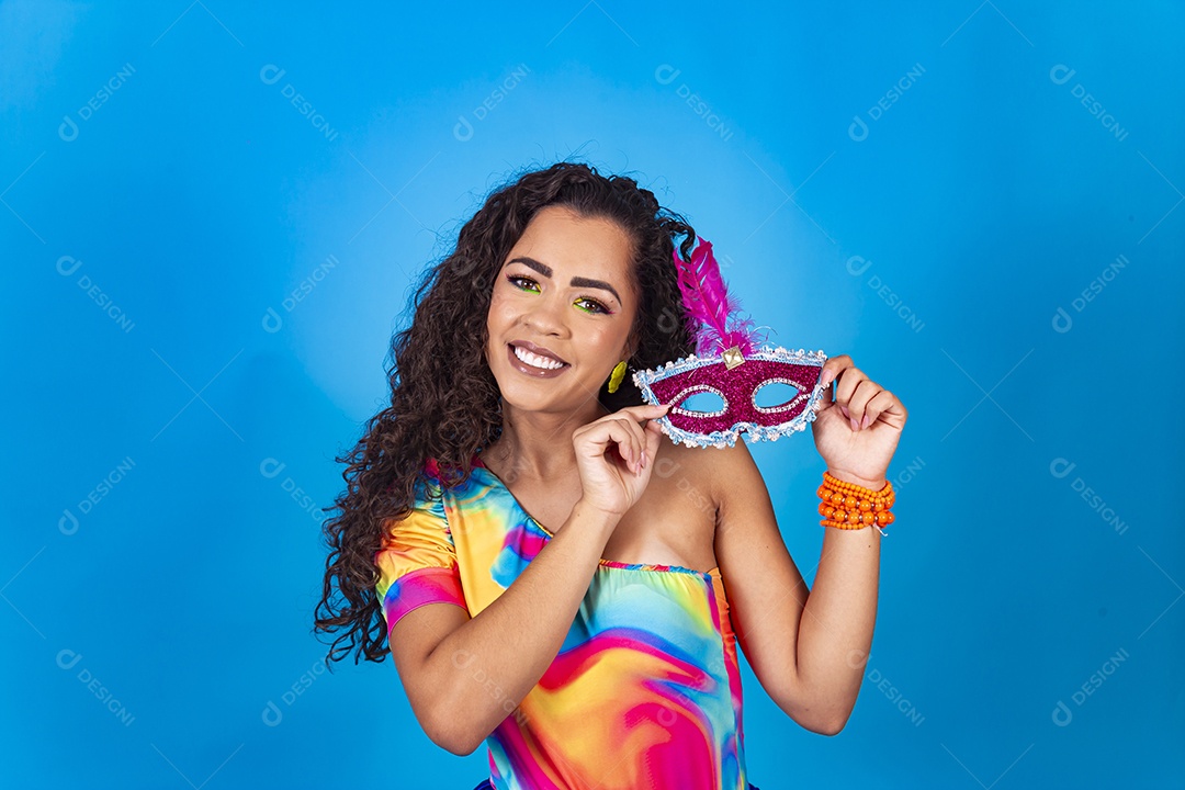 Linda mulher cabelo cacheado segurando máscara carnavalesca.