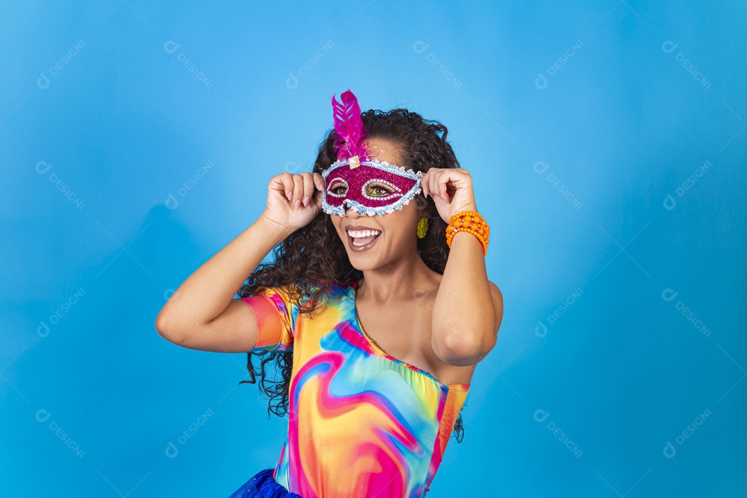 Linda mulher cabelo cacheado usando máscara carnavalesca.