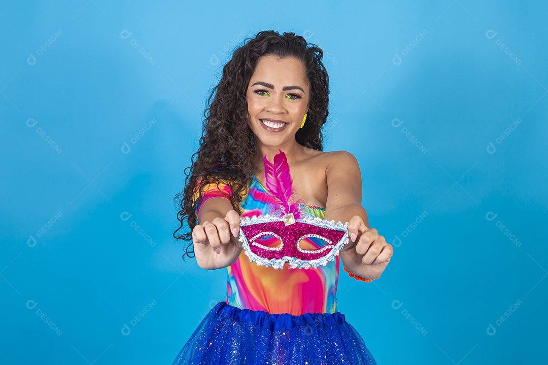 Linda mulher cabelo cacheado segurando máscara carnavalesca.
