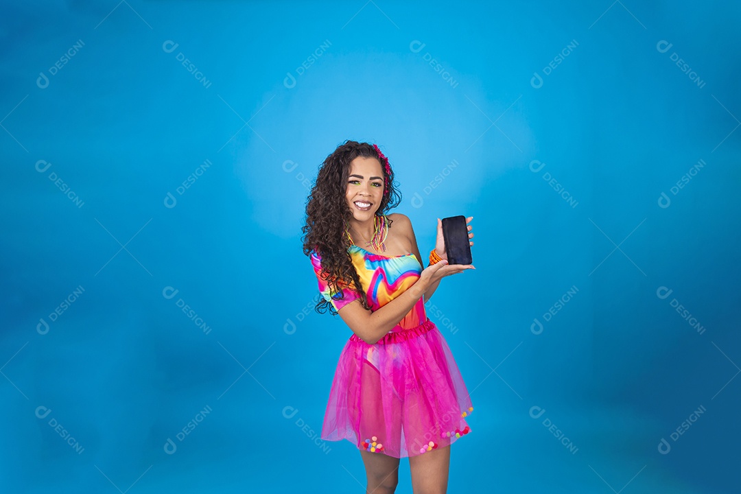 Linda mulher cabelo cacheado vestida com fantasia de carnaval segurando celular.