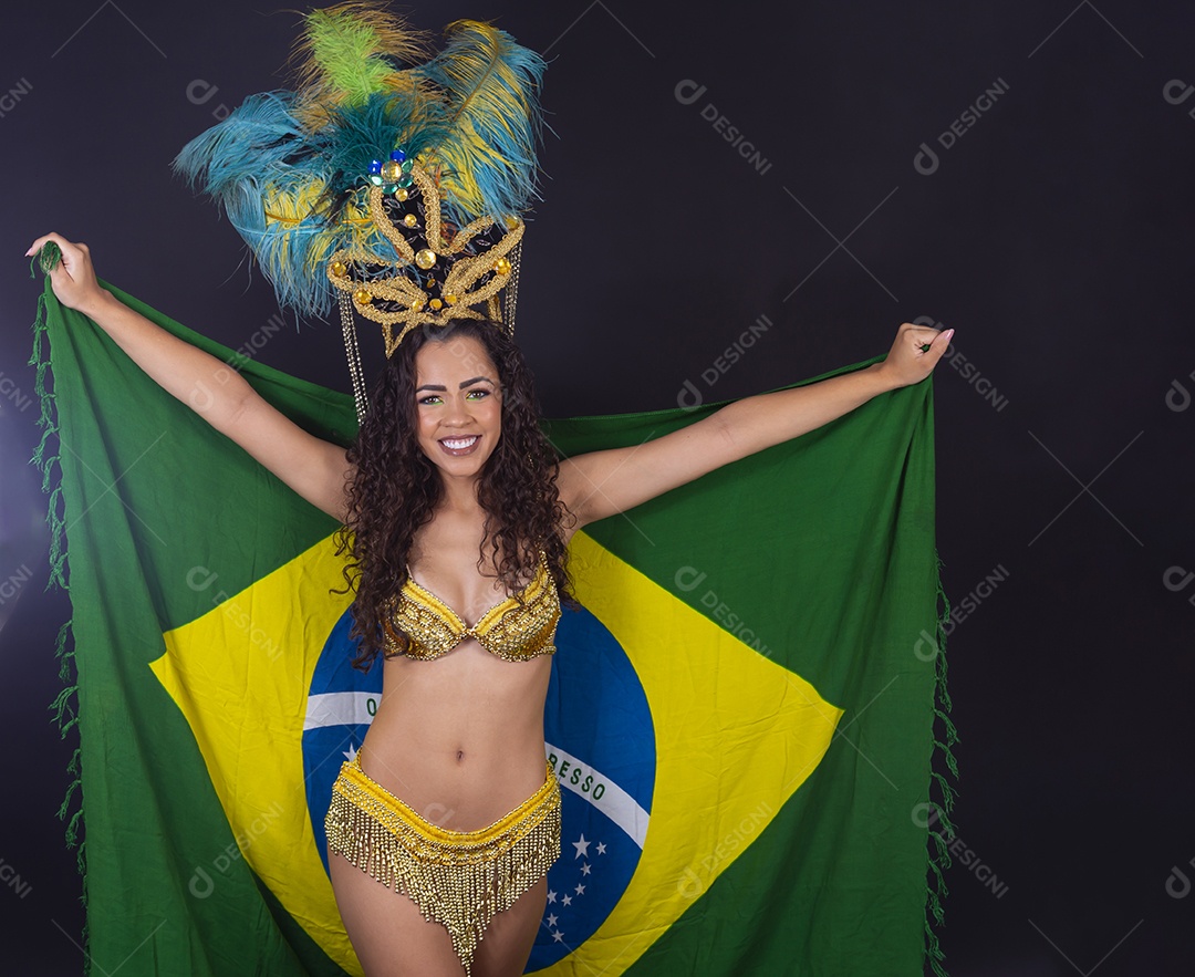 Linda passista fantasiada para o carnaval segurando bandeira do Brasil.