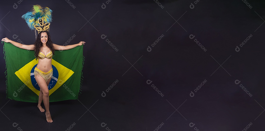 Linda passista fantasiada para o carnaval segurando bandeira do Brasil.