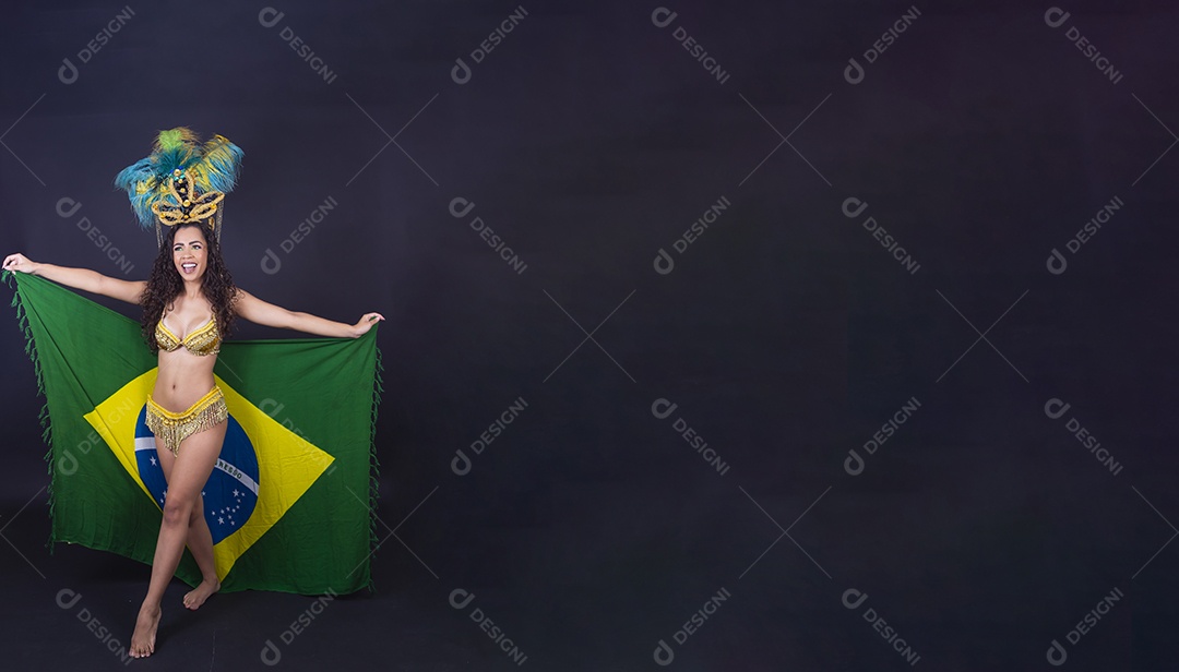 Linda passista fantasiada para o carnaval segurando bandeira do Brasil.