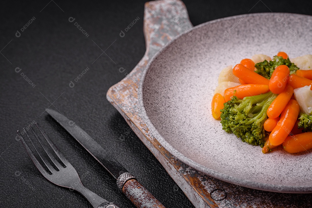 Deliciosos legumes frescos, brócolis, couve-flor, cenouras cozidas no vapor com sal, especiarias e ervas sobre fundo liso