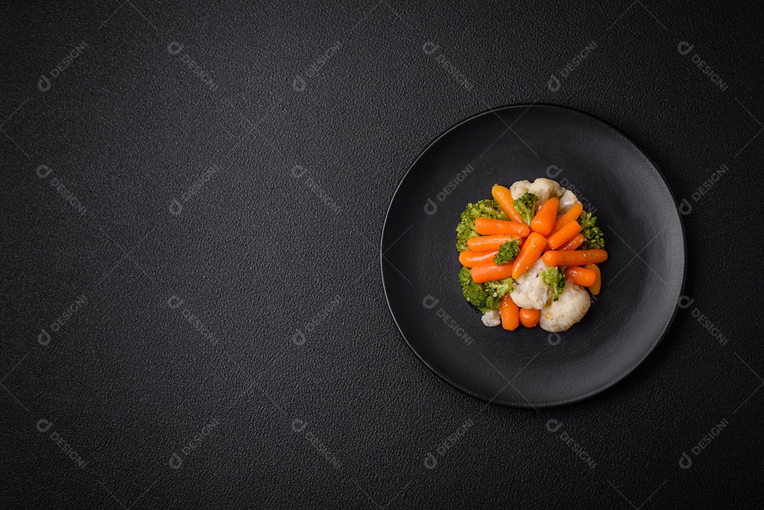 Deliciosos legumes frescos, brócolis, couve-flor, cenouras cozidas no vapor com sal, especiarias e ervas sobre fundo liso