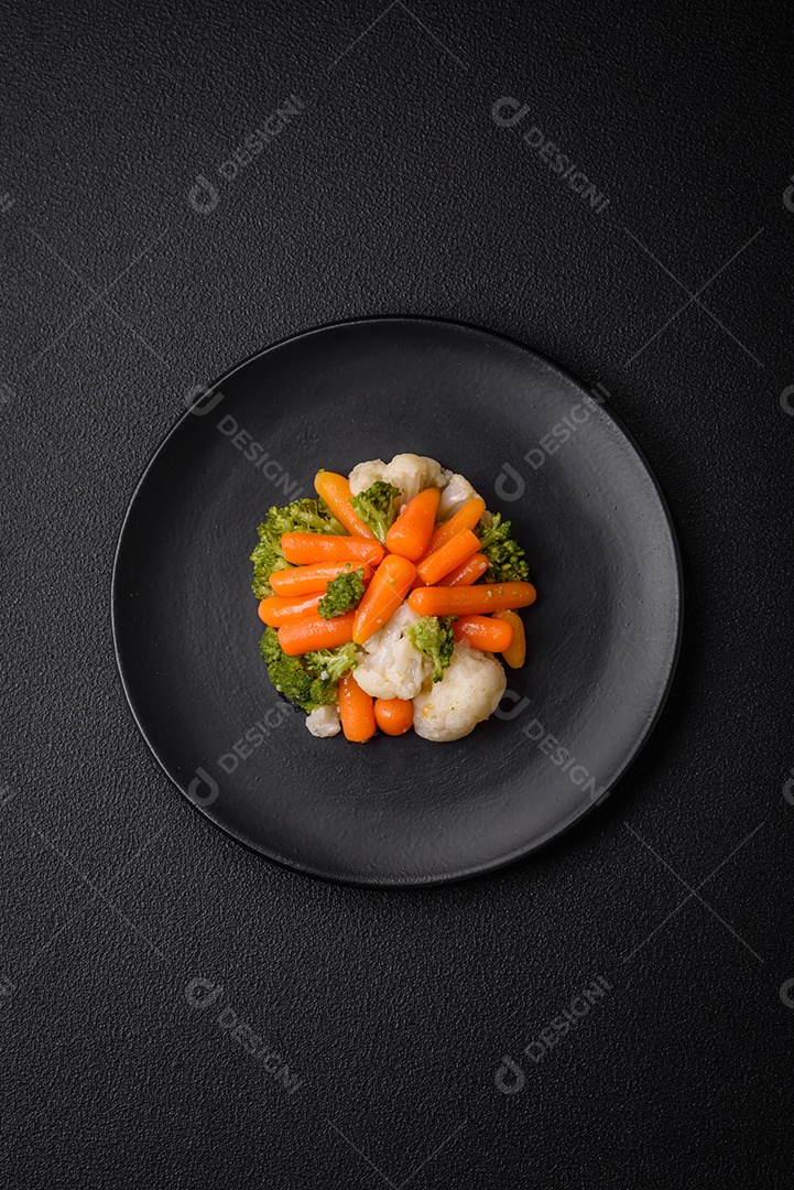 Deliciosos legumes frescos, brócolis, couve-flor, cenouras cozidas no vapor com sal, especiarias e ervas sobre fundo liso