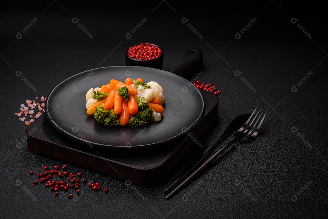 Deliciosos legumes frescos, brócolis, couve-flor, cenouras cozidas no vapor com sal, especiarias e ervas sobre fundo liso