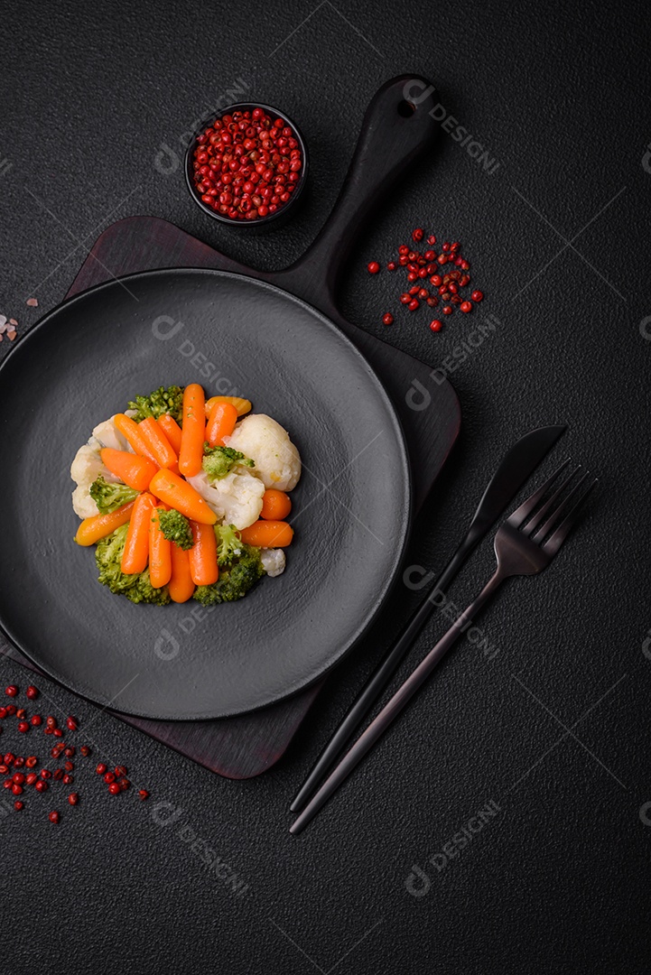 Deliciosos legumes frescos, brócolis, couve-flor, cenouras cozidas no vapor com sal, especiarias e ervas sobre fundo liso