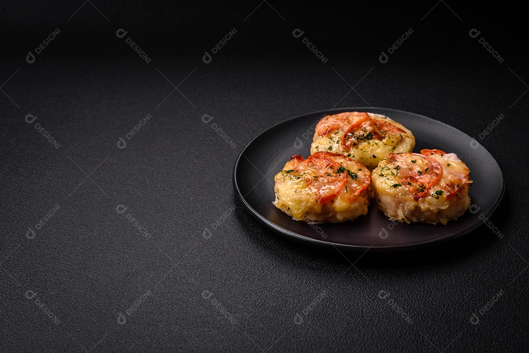Delicioso filé de peixe assado com queijo, tomate, sal, especiarias e ervas sobre um fundo escuro de concreto
