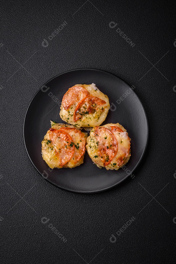 Delicioso filé de peixe assado com queijo, tomate, sal, especiarias e ervas sobre um fundo escuro de concreto