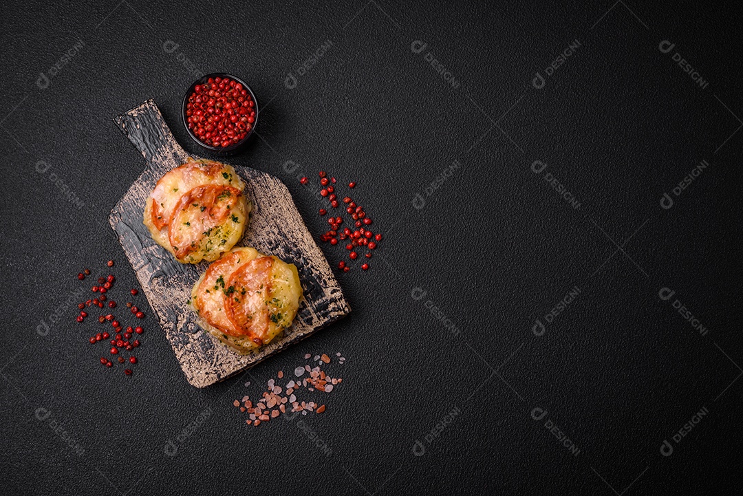 Delicioso filé de peixe assado com queijo, tomate, sal, especiarias e ervas sobre um fundo escuro de concreto