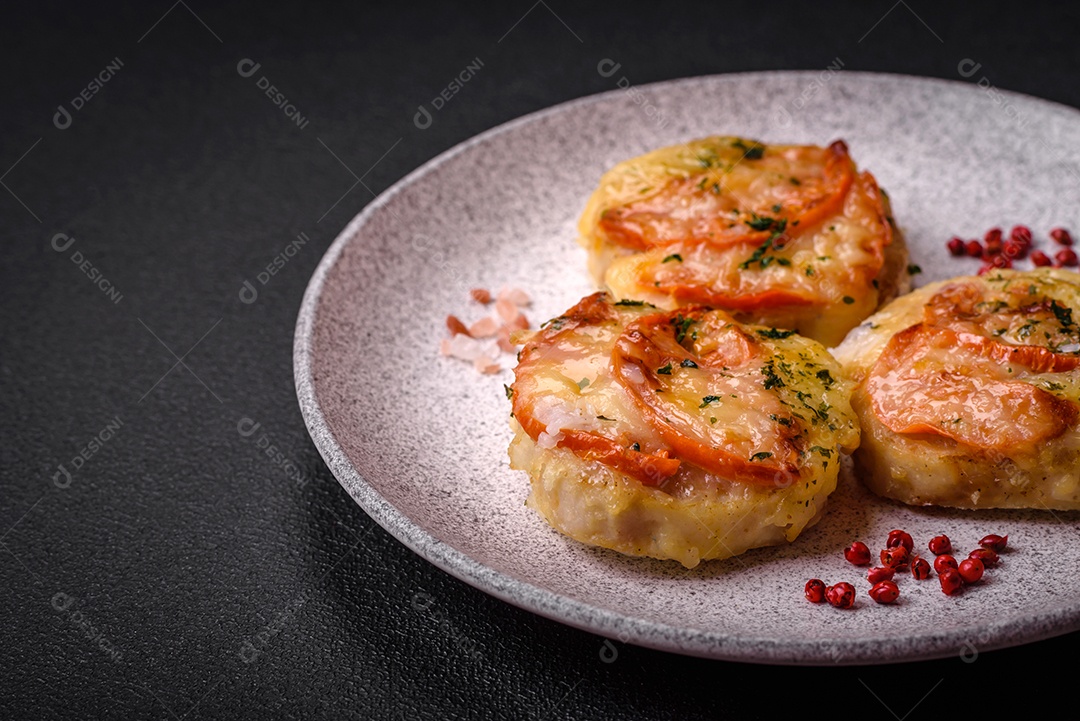 Delicioso filé de peixe assado com queijo, tomate, sal, especiarias e ervas sobre um fundo escuro de concreto