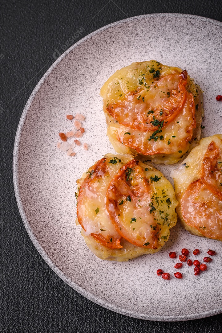 Delicioso filé de peixe assado com queijo, tomate, sal, especiarias e ervas sobre um fundo escuro de concreto