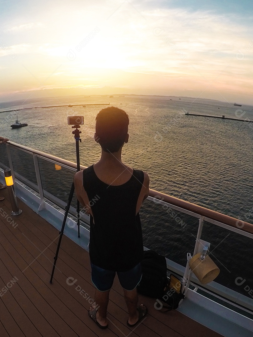 Retrato de um jovem turista negro em frente a um navio de cruzeiro em um céu nublado