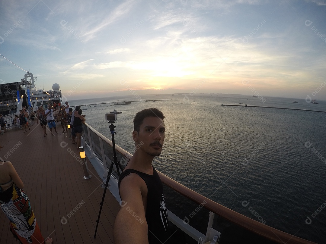 Retrato de um jovem turista negro no convés de um navio de cruzeiro em frente ao pôr do