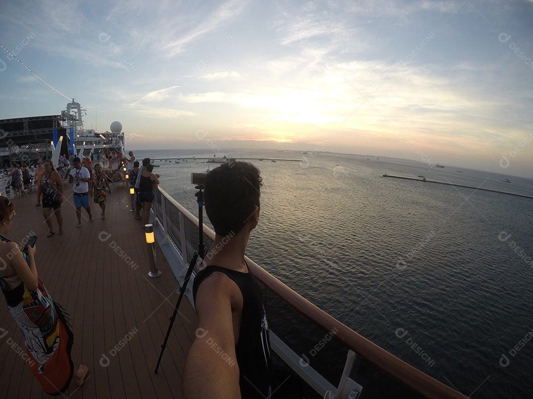 Retrato de um jovem turista negro no convés de um navio de cruzeiro em frente ao pôr do sol