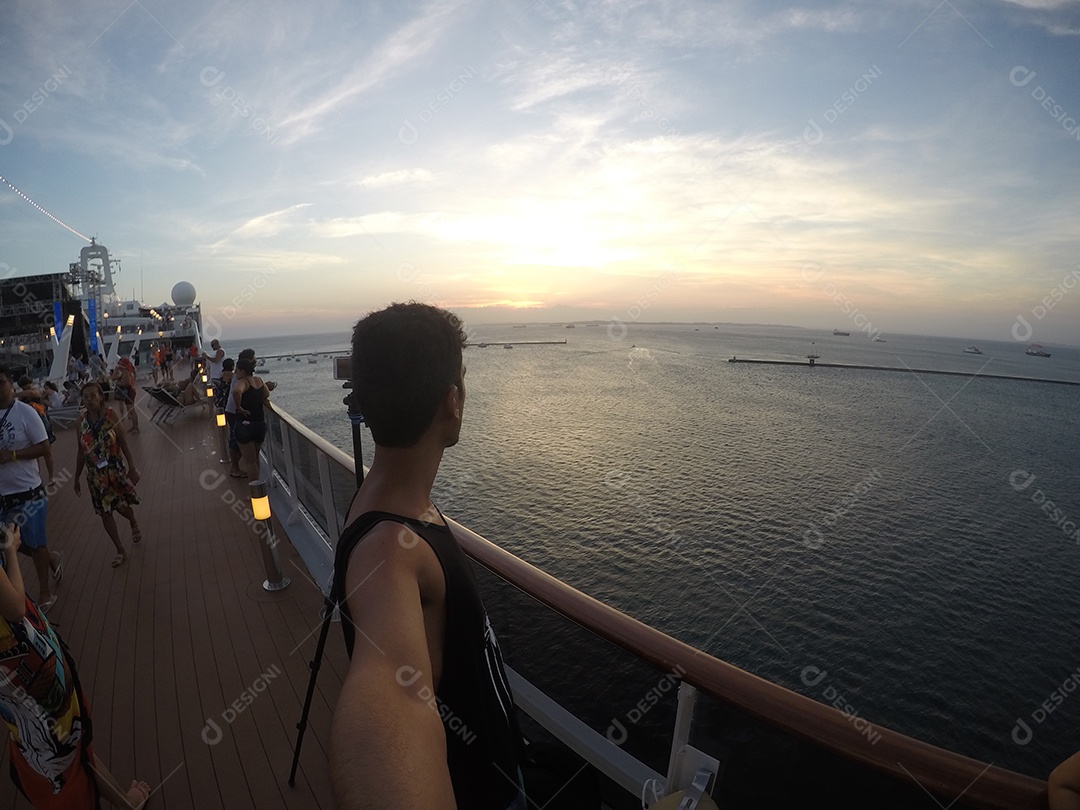 Retrato de um jovem turista negro no convés de um navio de cruzeiro em frente ao pôr do sol