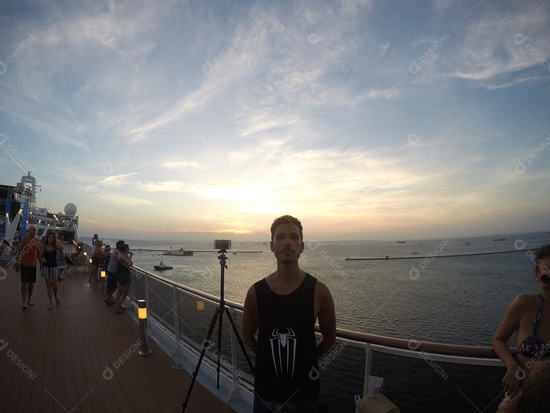 Retrato de um jovem turista negro no convés de um navio de cruzeiro em frente ao pôr do sol