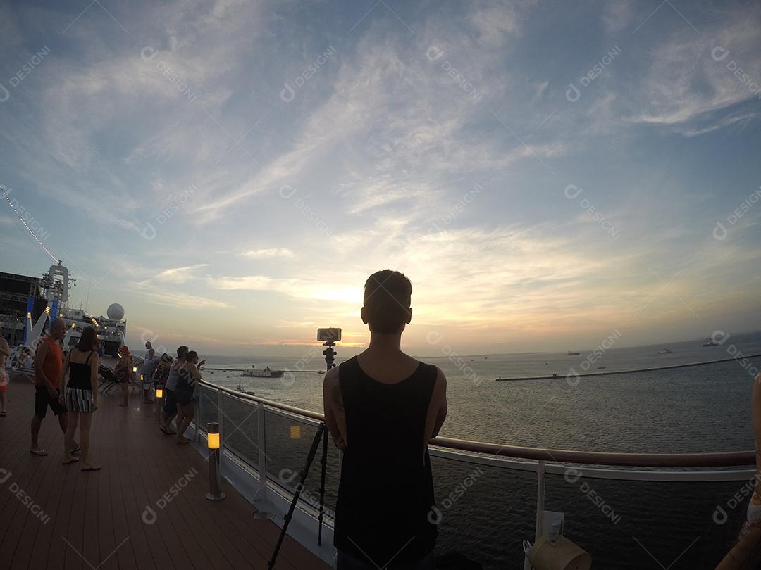 Retrato de um jovem turista negro no convés de um navio de cruzeiro em frente ao pôr do sol