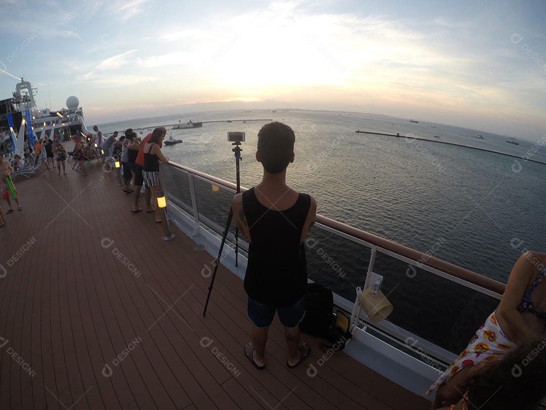 Retrato de um jovem turista negro no convés de um navio de cruzeiro em frente ao pôr do sol