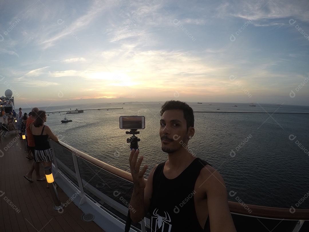 Retrato de um jovem turista negro no convés de um navio de cruzeiro em frente ao pôr do sol