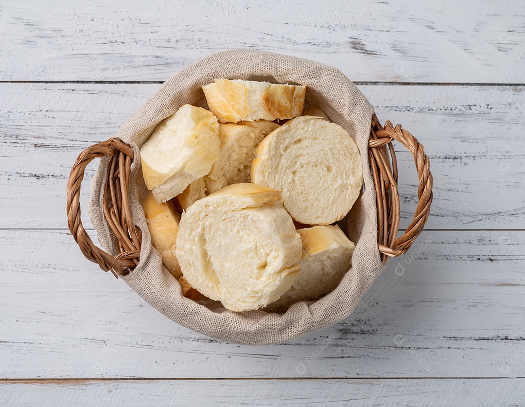 Pão francês em fatias sobre mesa de madeira