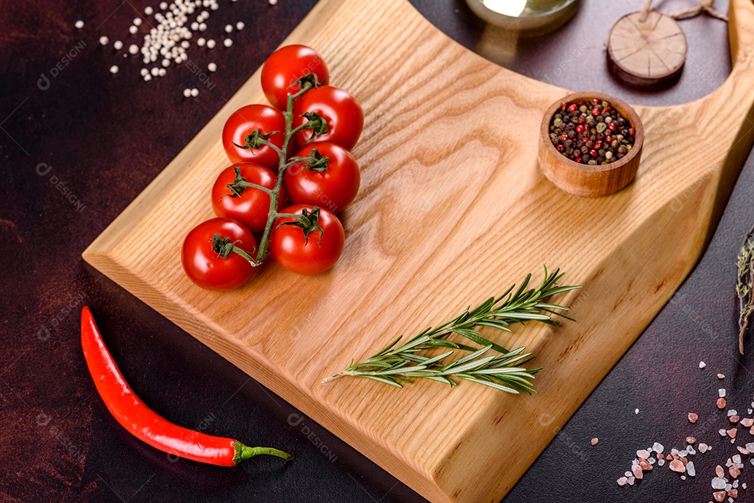 Tábua de corte com sal, especiarias e ervas sobre um fundo escuro de concreto. Cozinhar alimentos saudáveis