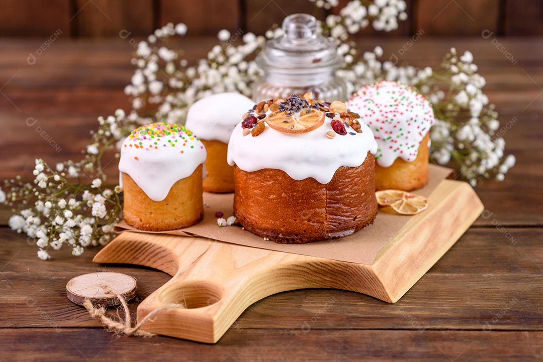 Bolos festivos com esmalte branco, nozes e passas com ovos de Páscoa na mesa festiva. Preparativos para a Páscoa