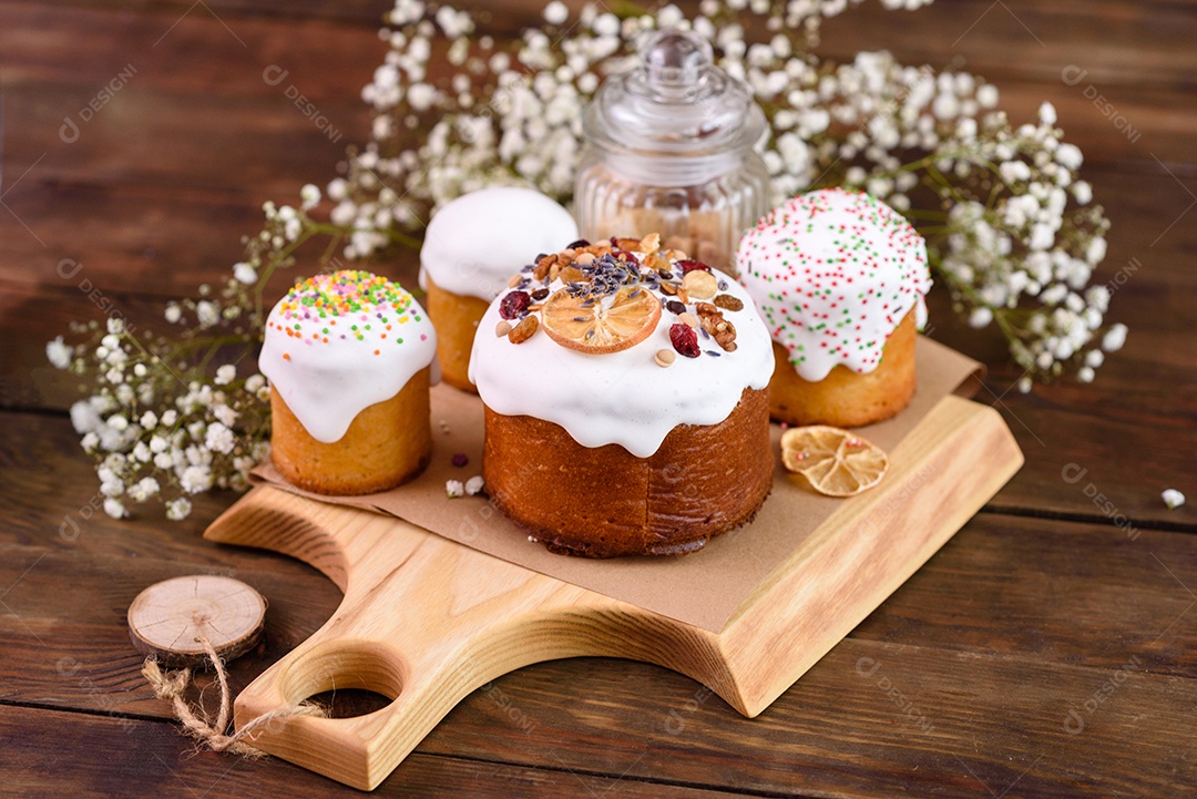 Bolos festivos com esmalte branco, nozes e passas com ovos de Páscoa na mesa festiva. Preparativos para a Páscoa