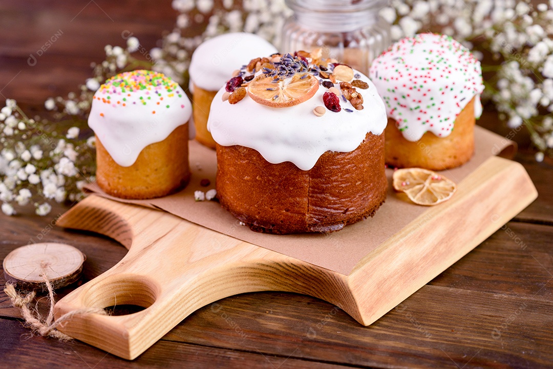 Bolos festivos com esmalte branco, nozes e passas com ovos de Páscoa na mesa festiva. Preparativos para a Páscoa