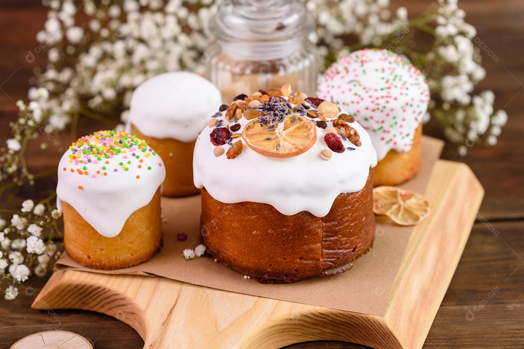 Bolos festivos com esmalte branco, nozes e passas com ovos de Páscoa na mesa festiva. Preparativos para a Páscoa