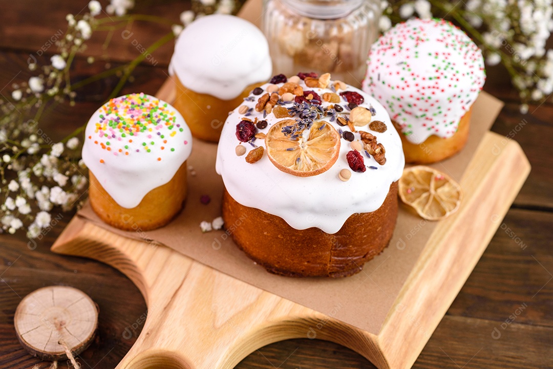 Bolos festivos com esmalte branco, nozes e passas com ovos de Páscoa na mesa festiva. Preparativos para a Páscoa