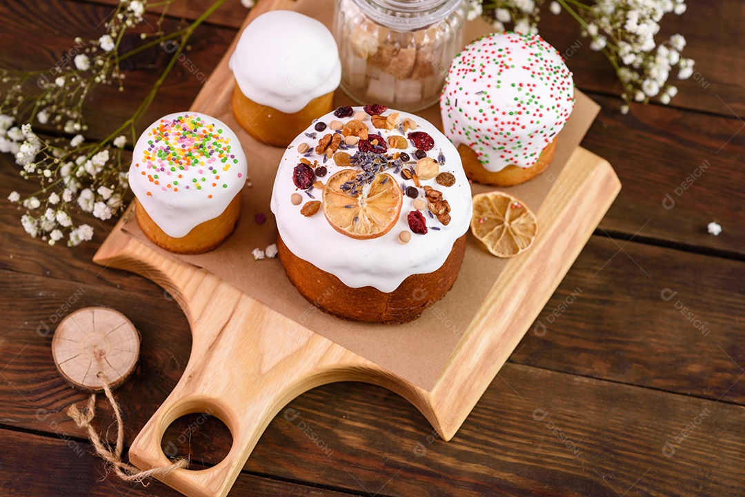 Bolos festivos com esmalte branco, nozes e passas com ovos de Páscoa na mesa festiva. Preparativos para a Páscoa