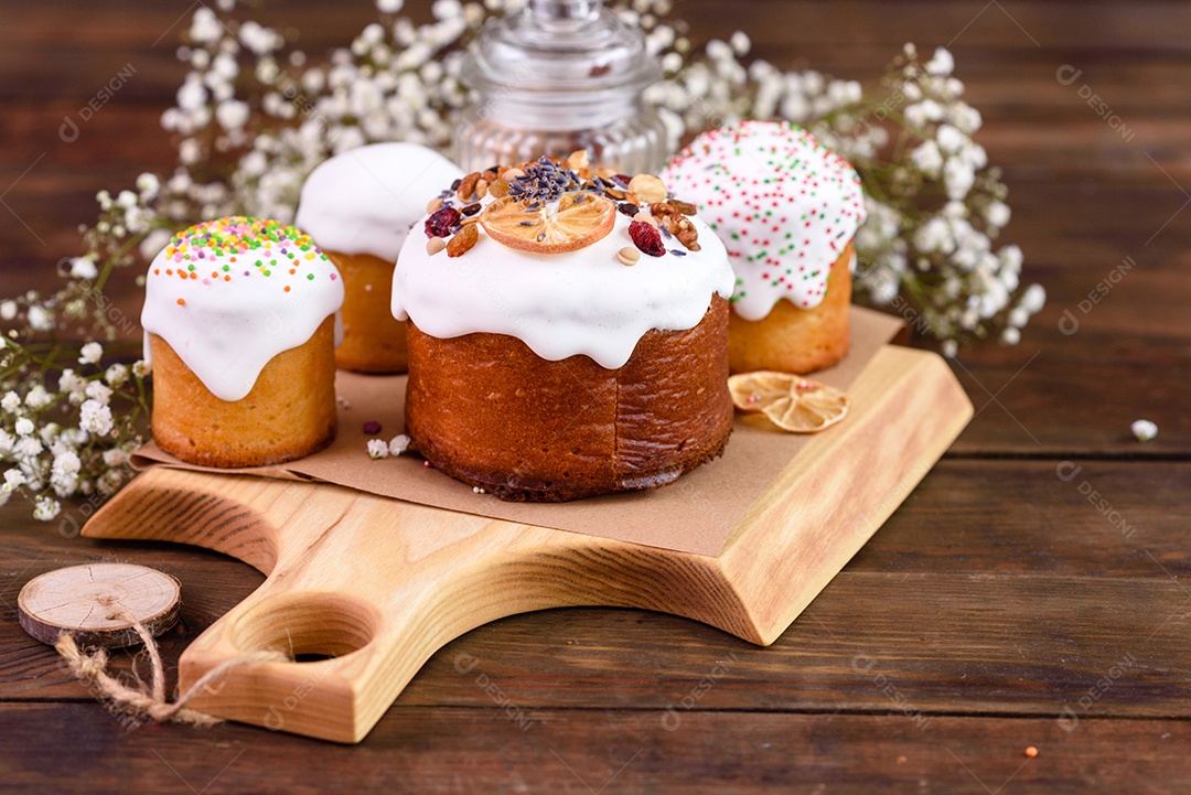 Bolos festivos com esmalte branco, nozes e passas com ovos de Páscoa na mesa festiva. Preparativos para a Páscoa