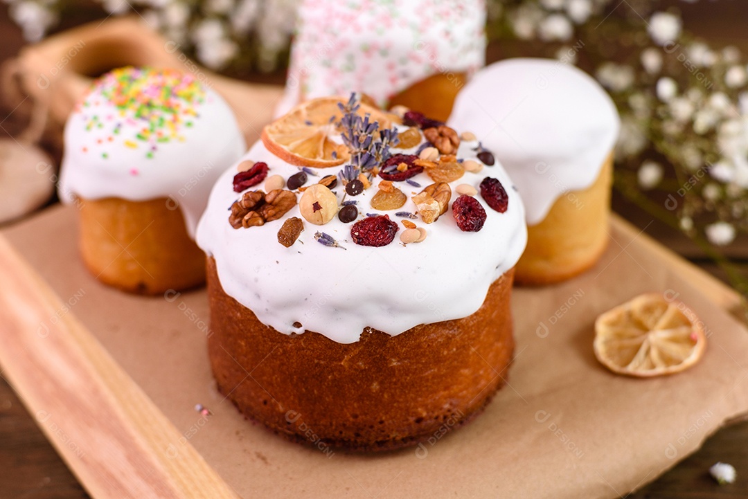 Bolos festivos com esmalte branco, nozes e passas com ovos de Páscoa na mesa festiva. Preparativos para a Páscoa