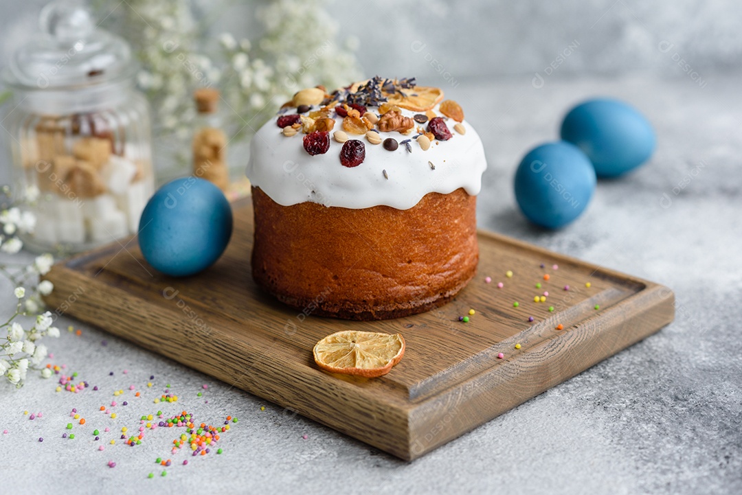Bolos festivos com esmalte branco, nozes e passas com ovos de Páscoa na mesa festiva. Preparativos para a Páscoa