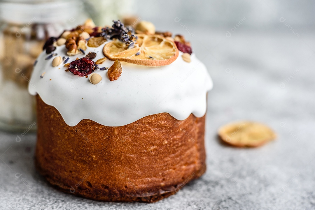 Bolos festivos com esmalte branco, nozes e passas com ovos de Páscoa na mesa festiva. Preparativos para a Páscoa