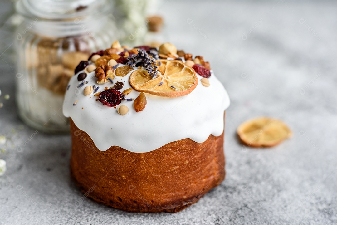Bolos festivos com esmalte branco, nozes e passas com ovos de Páscoa na mesa festiva. Preparativos para a Páscoa