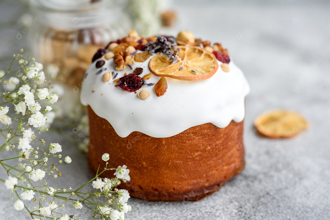 Bolos festivos com esmalte branco, nozes e passas com ovos de Páscoa na mesa festiva. Preparativos para a Páscoa
