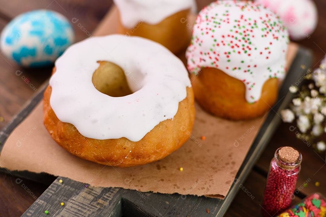 Bolos festivos com esmalte branco, nozes e passas com ovos de Páscoa na mesa festiva. Preparativos para a Páscoa