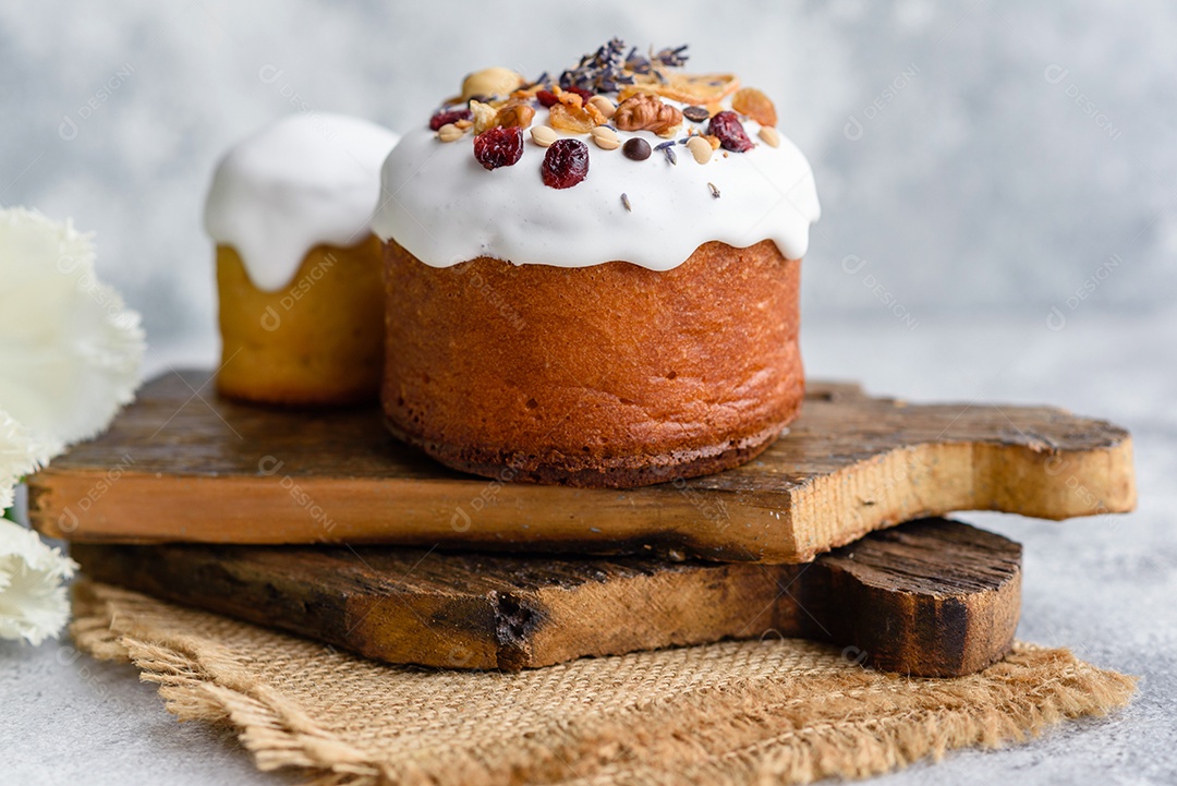Bolos festivos com esmalte branco, nozes e passas com ovos de Páscoa na mesa festiva. Preparativos para a Páscoa
