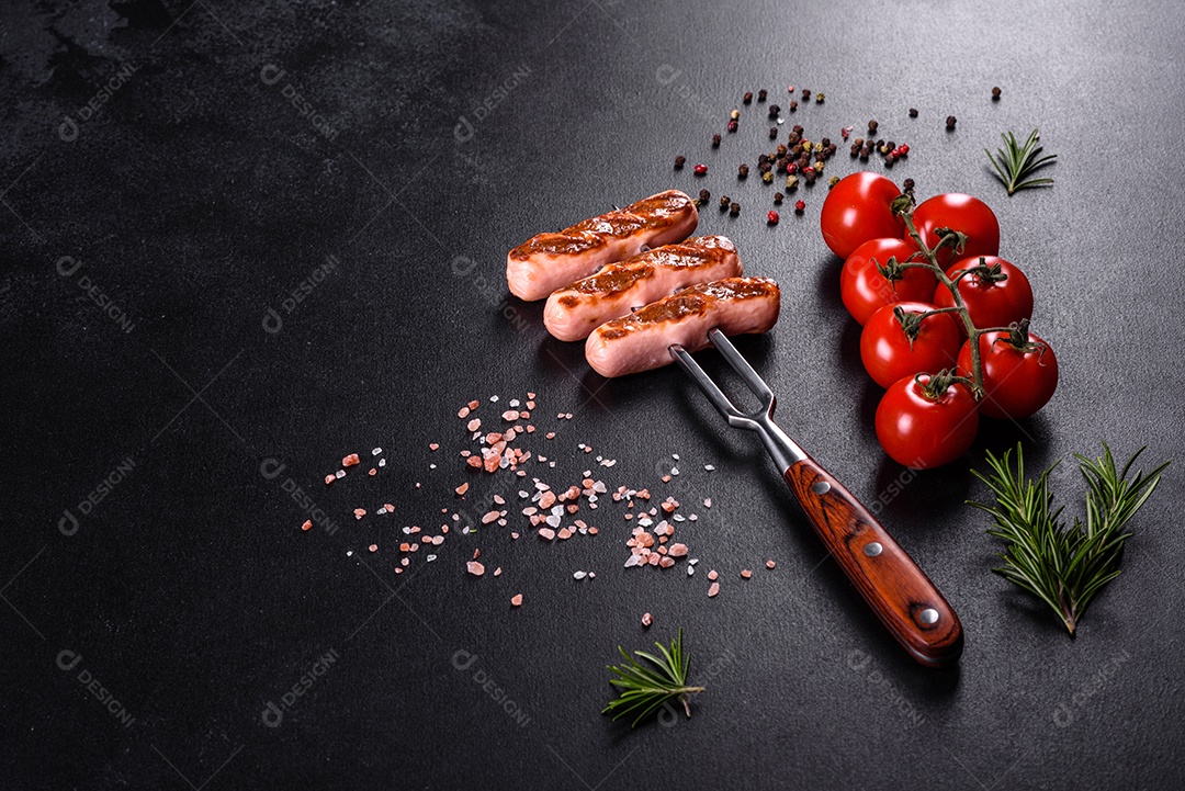 Saborosos enchidos frescos grelhados com legumes, especiarias e ervas. Foto do prato acabado em uma mesa de concreto escuro
