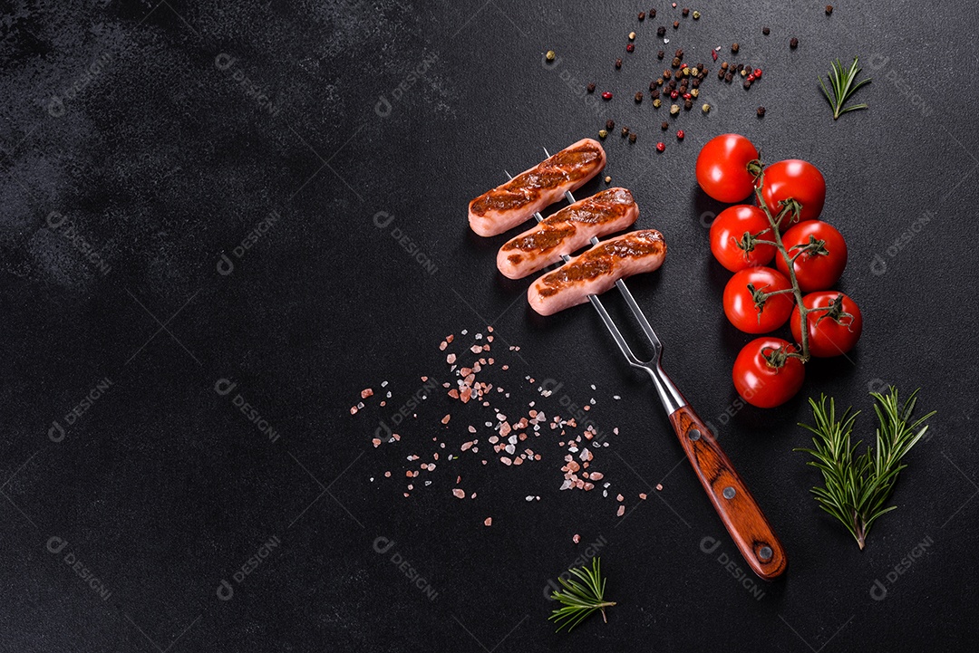 Saborosos enchidos frescos grelhados com legumes, especiarias e ervas. Foto do prato acabado em uma mesa de concreto escuro