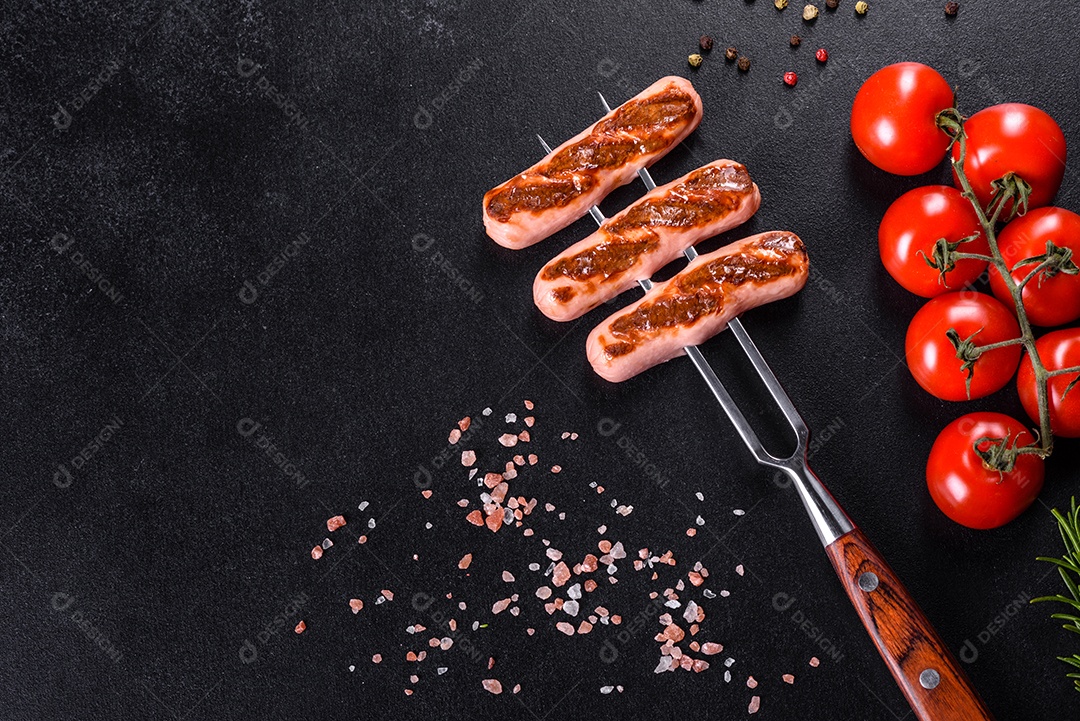 Saborosos enchidos frescos grelhados com legumes, especiarias e ervas. Foto do prato acabado em uma mesa de concreto escuro