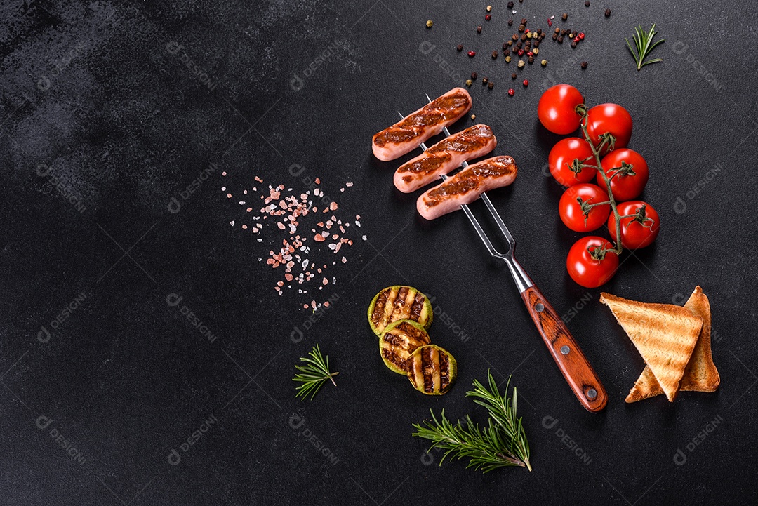 Saborosos enchidos frescos grelhados com legumes, especiarias e ervas. Foto do prato acabado em uma mesa de concreto escuro