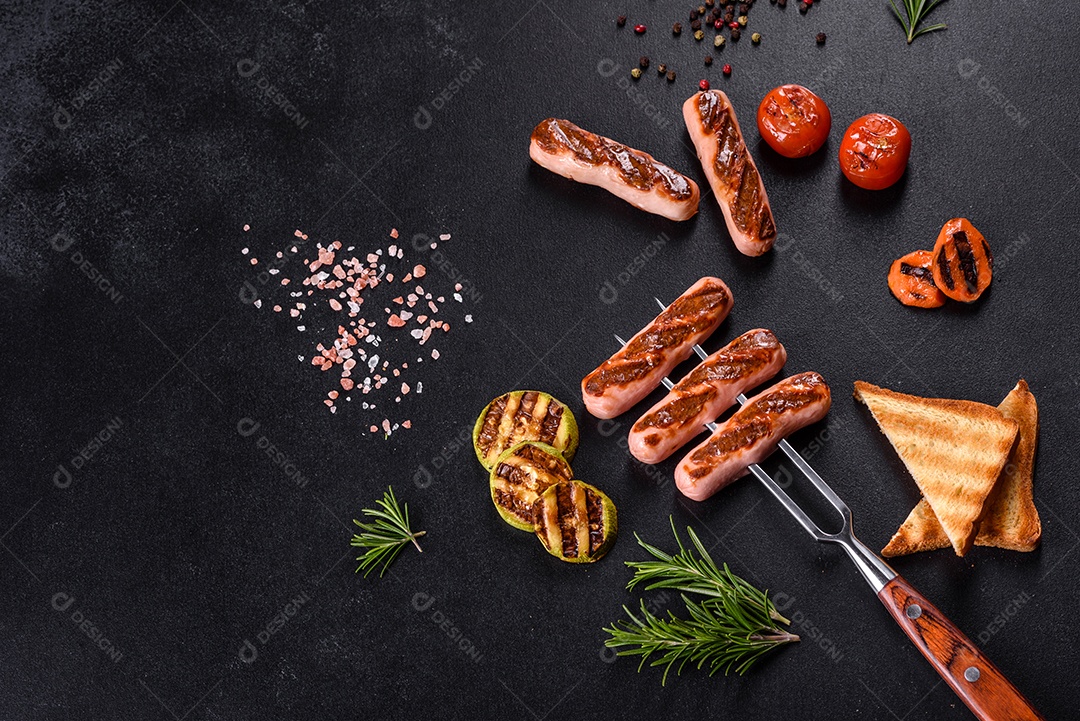 Saborosos enchidos frescos grelhados com legumes, especiarias e ervas. Foto do prato acabado em uma mesa de concreto escuro
