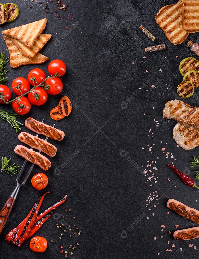 Saborosos enchidos frescos grelhados com legumes, especiarias e ervas. Foto do prato acabado em uma mesa de concreto escuro