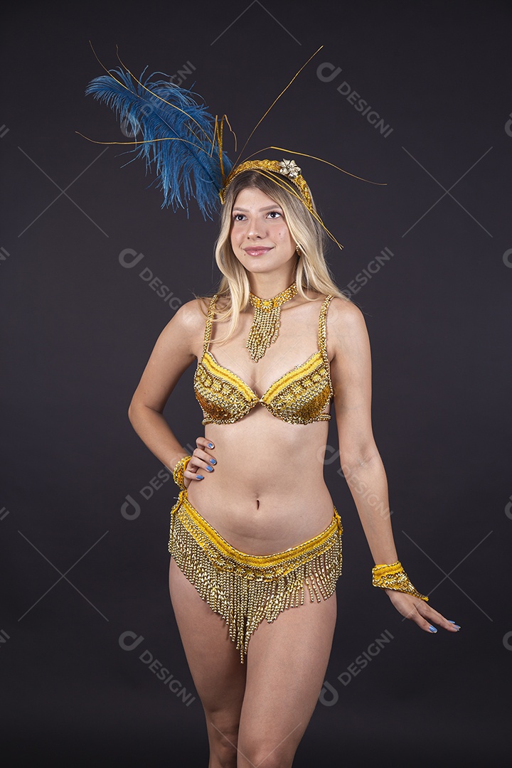 Linda passista loira fantasiada para o carnaval sobre um fundo isolado verde.