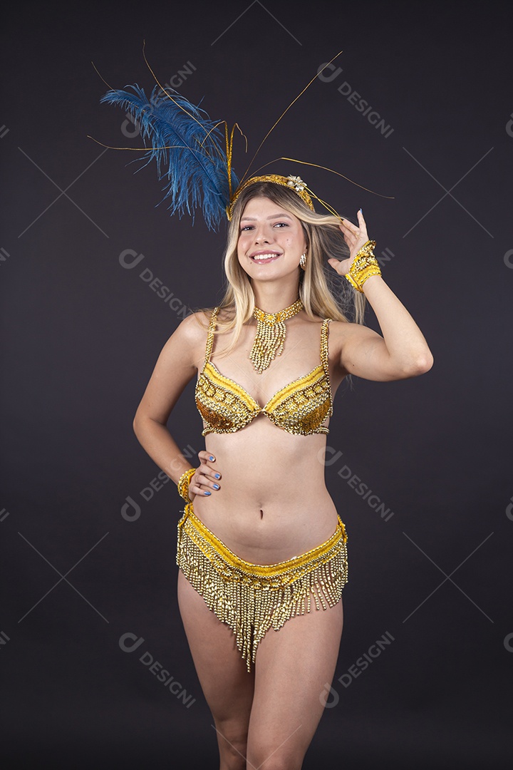 Linda passista loira fantasiada para o carnaval sobre um fundo isolado preto.